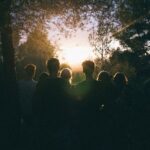 A group of friends enjoying a scenic sunset in a forest, capturing a moment of togetherness.